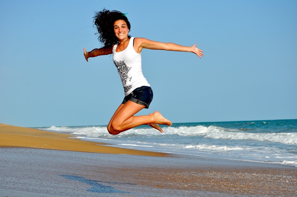 Mulher feliz na praia - Vida saudável
